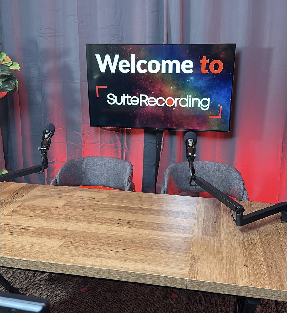 SuiteRecording podcast desk setup with red studio lighting and branded welcome screen